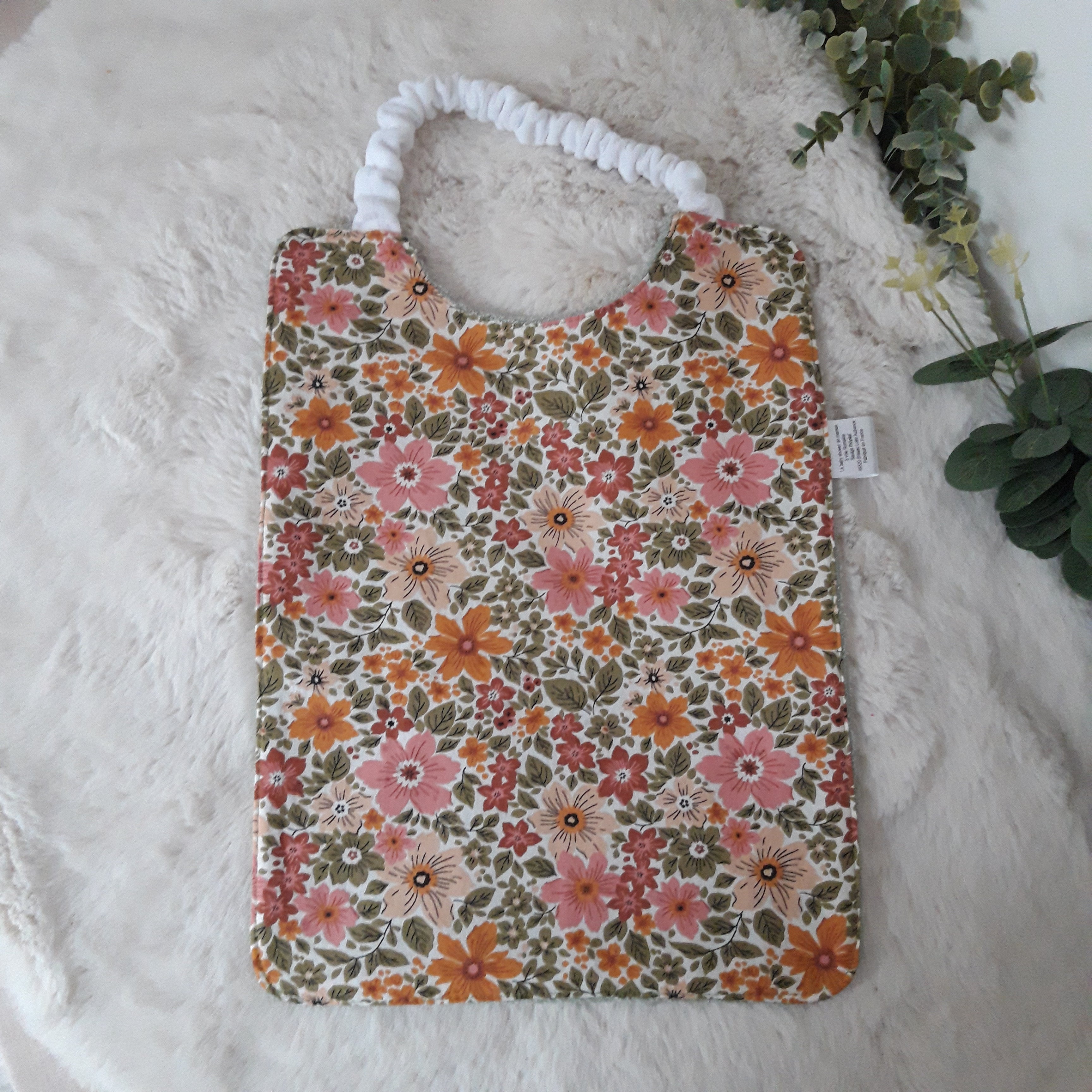 Bavoir élastique fleurs dans la verdure