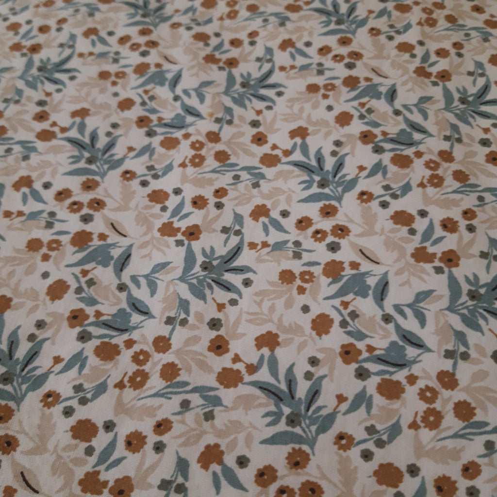 Bavoir élastique fleurs beiges et bleues